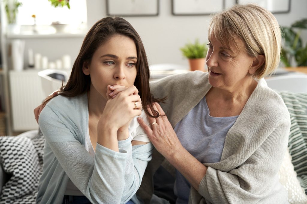 Mother comforting upset adult daughter