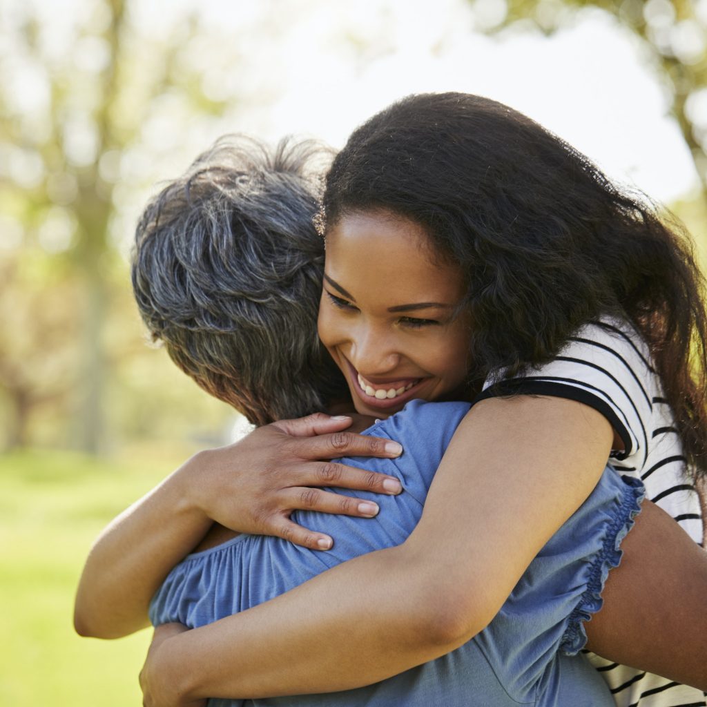 Senior Mother With Adult Daughter Hugging In Park