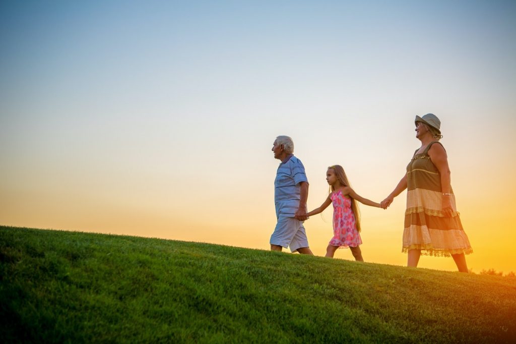 Girl with grandparents at sunset